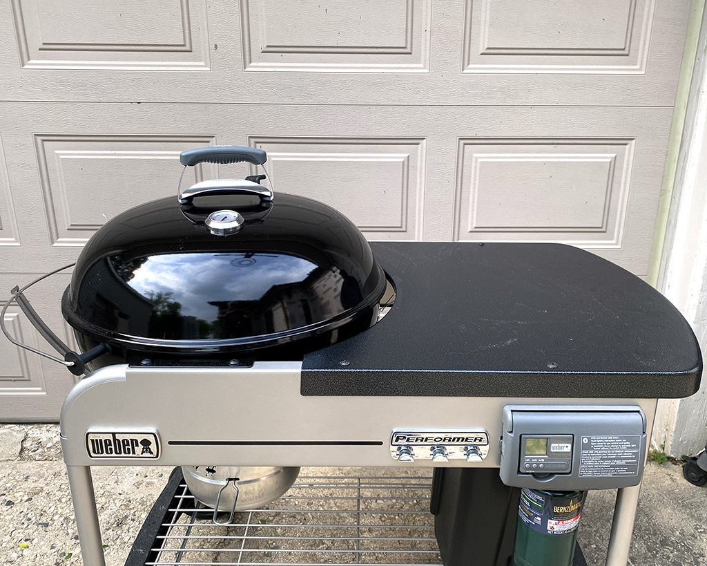 Top view of Weber 22 in. Performer Deluxe Charcoal Grill with a black lid. Good view of the rolling prep station.