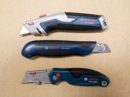 Three Bosch utility knives laid out over a work table. The knives from top to bottom are the BOSCH H11-12100-1 retractable utility knife, the BOSCH H11-13000-1 snap-off utility knife, and the BOSCH H11-11100-1 folding utility knife.