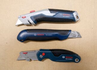 Three Bosch utility knives laid out over a work table. The knives from top to bottom are the BOSCH H11-12100-1 retractable utility knife, the BOSCH H11-13000-1 snap-off utility knife, and the BOSCH H11-11100-1 folding utility knife.