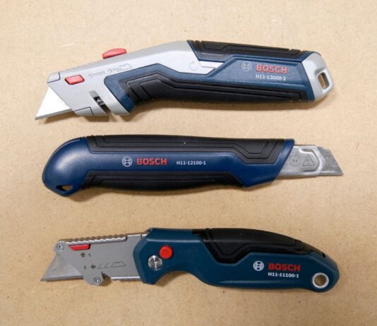 Three Bosch utility knives laid out over a work table. The knives from top to bottom are the BOSCH H11-12100-1 retractable utility knife, the BOSCH H11-13000-1 snap-off utility knife, and the BOSCH H11-11100-1 folding utility knife.