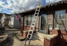 Werner TS1250 telescoping ladder, fully extended at 12.5 feet reaches from the driveway to past the roof or a brown ranch home that still has Christmas icicle lights on it.