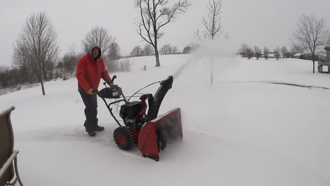 Craftsman 28 inch two stage snow blower throwing snow across a yard