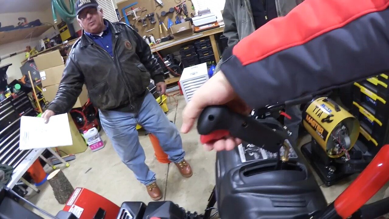 Hand on the steering trigger of the Craftsman snow blower