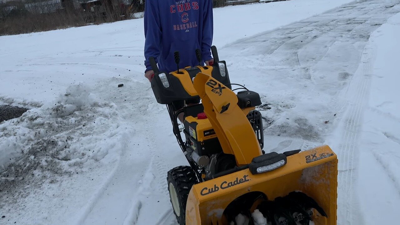 Cub Cadet 2X EFI cutting through snow on uneven asphalt