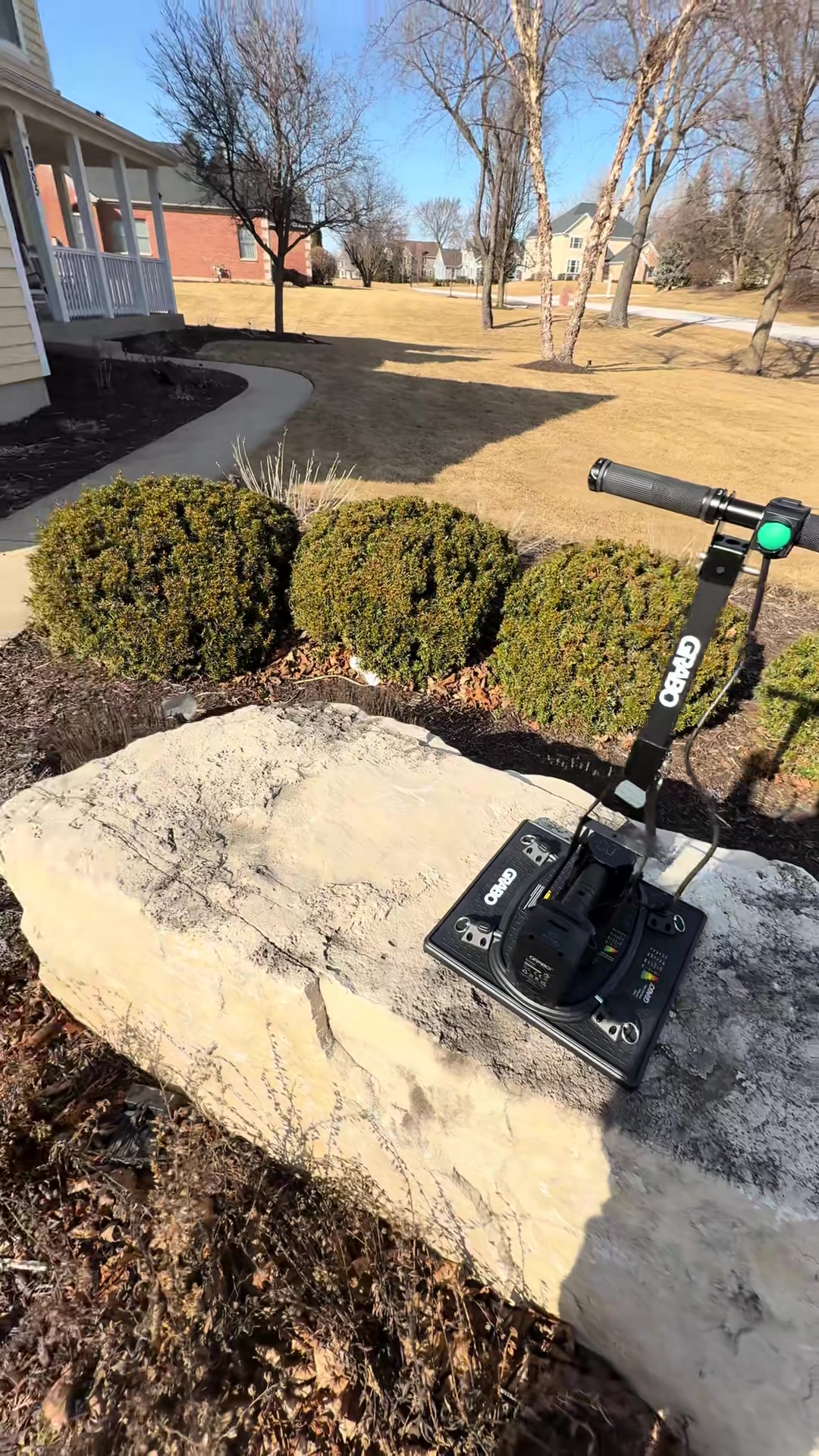 GRABO HighFlow vacuum lifter with T-bar handle gripping the top of a large boulder