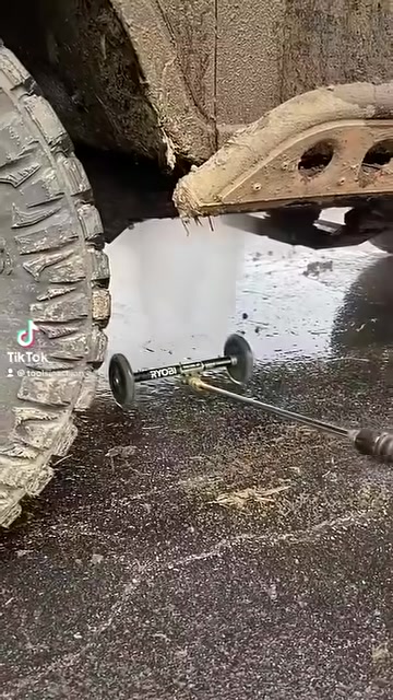 RYOBI pressure washer water broom rolling into position under a vehicle