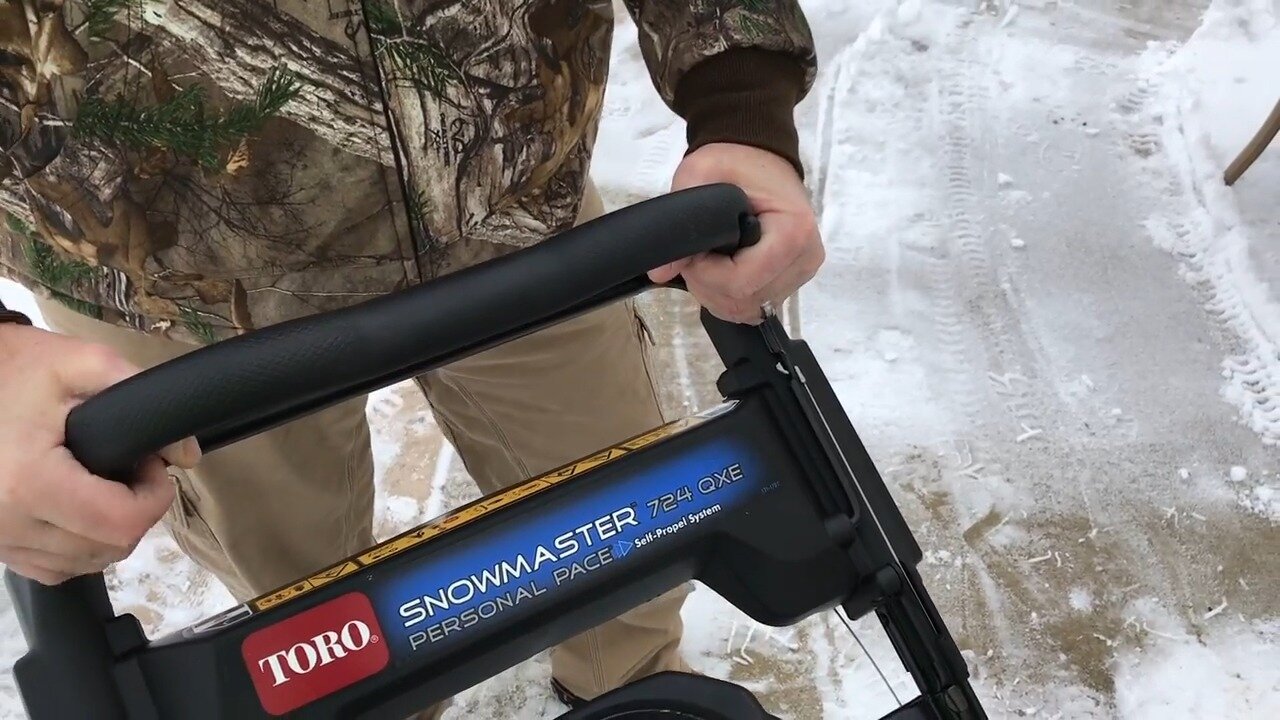 Hands on the SnowMaster handlebar of the Toro 724 QXE