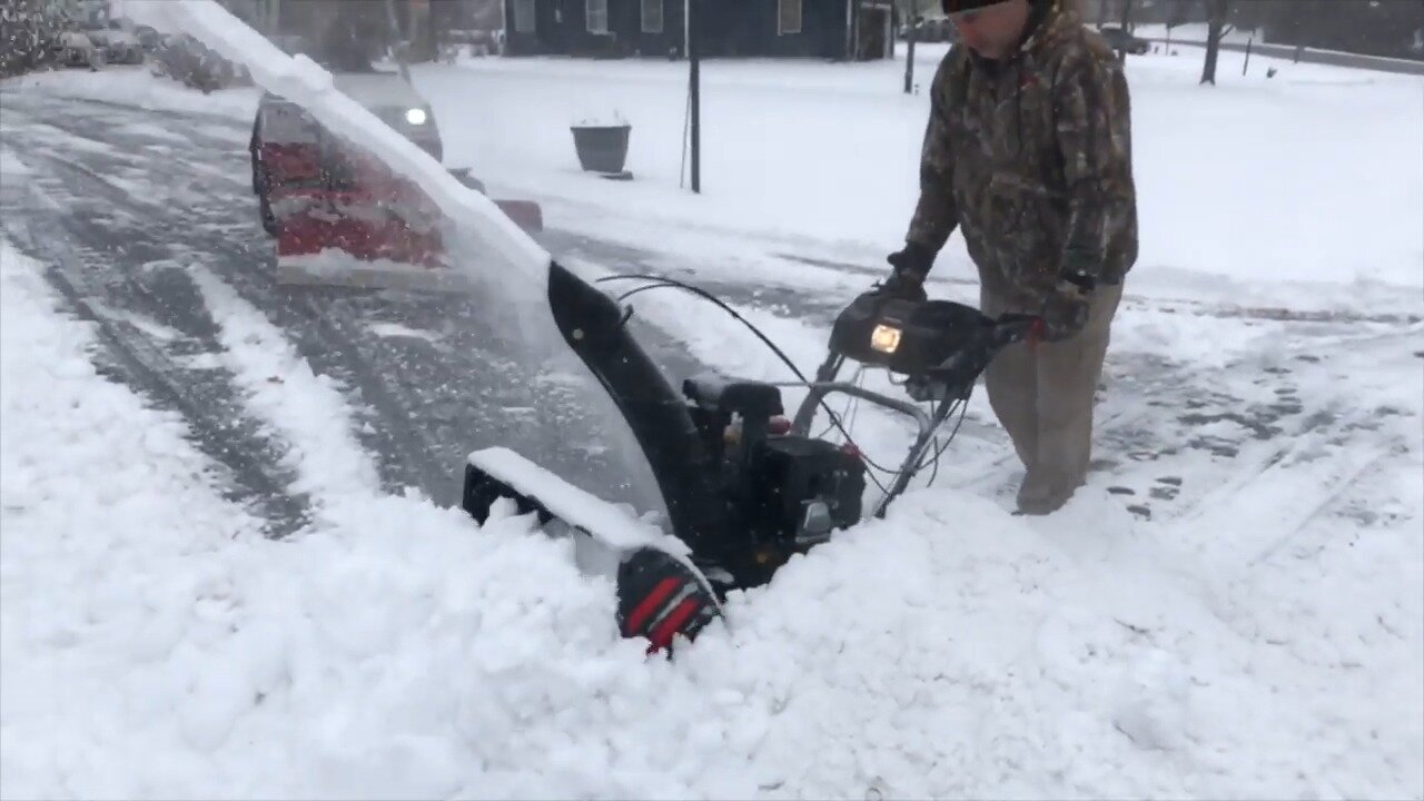 Neighbor clearing a snow pile with a Troy Bilt snow thrower