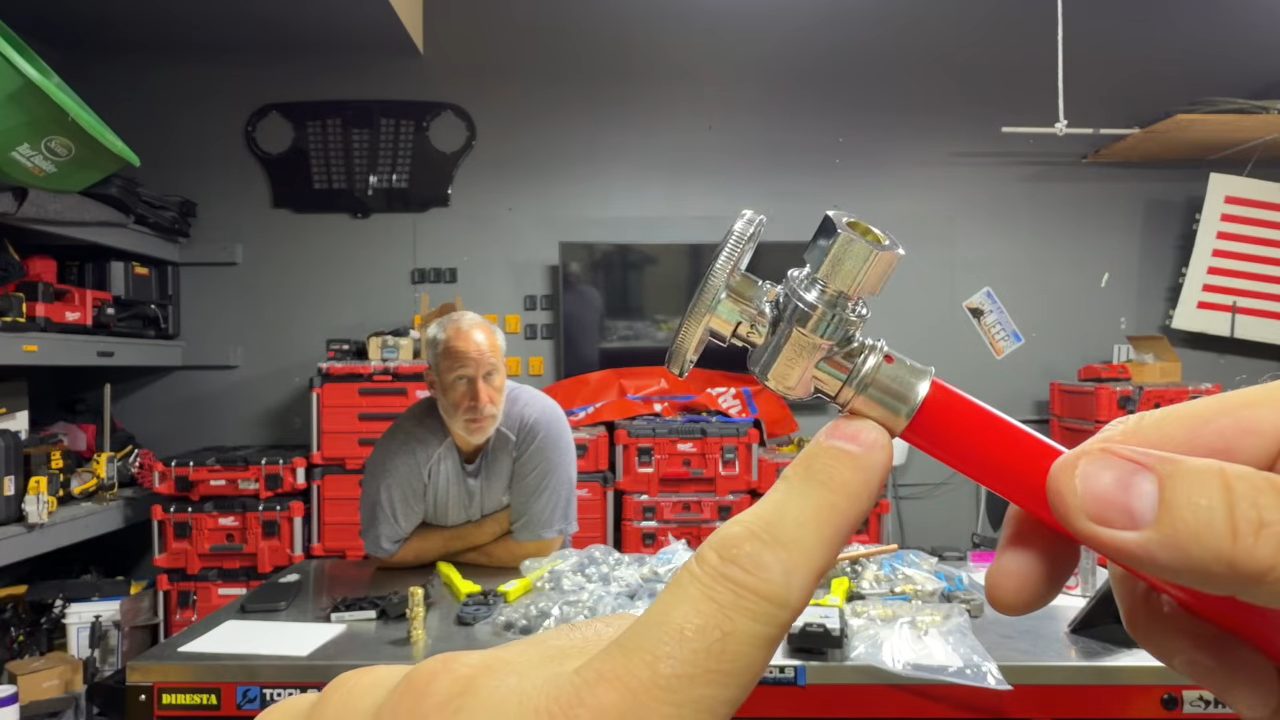 Stop valve with red PEX pipe pushed into its attached stainless steel press sleeve