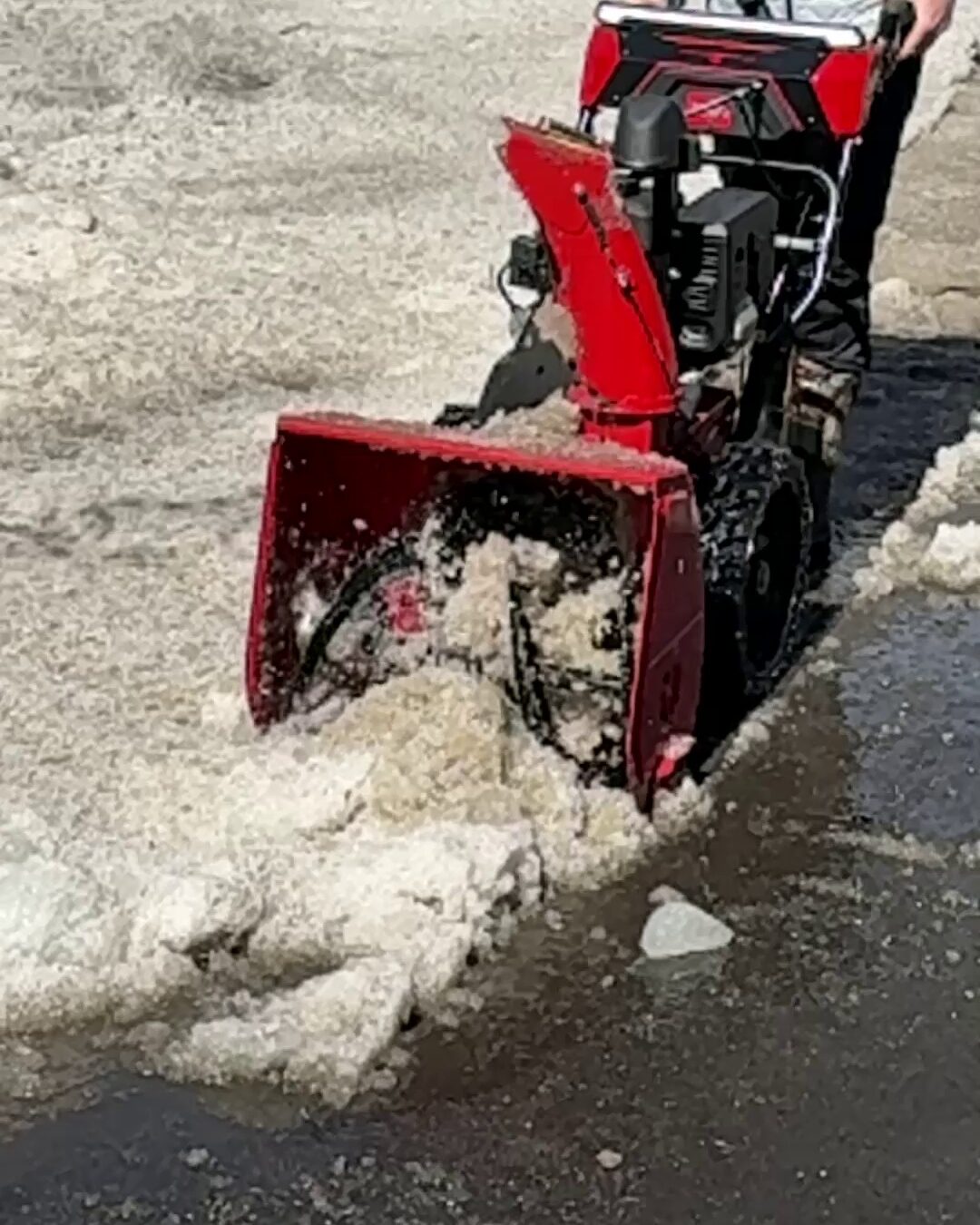 Toro Power Max HD snow blower chewing through a bank of wet slush in a parking lot