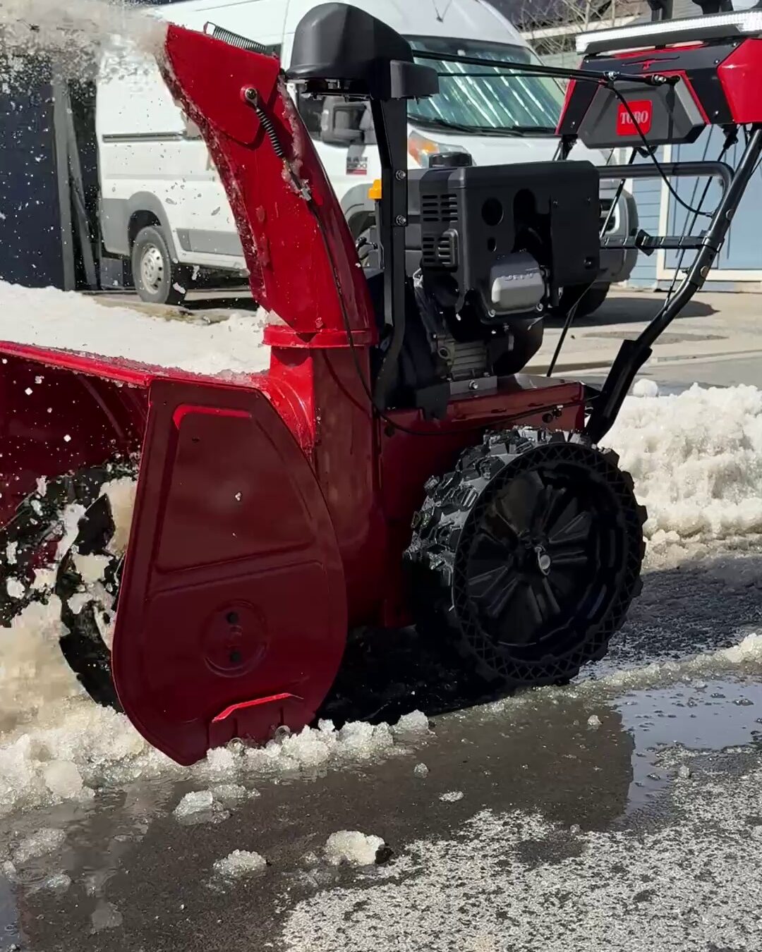 Toro Power Max HD snow blower clearing heavy wet snow from a street with never flat airless tires